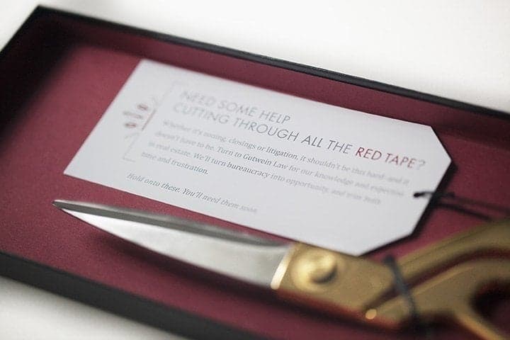 Printed document on burgundy desk mat with proofreading pen and eyeglasses