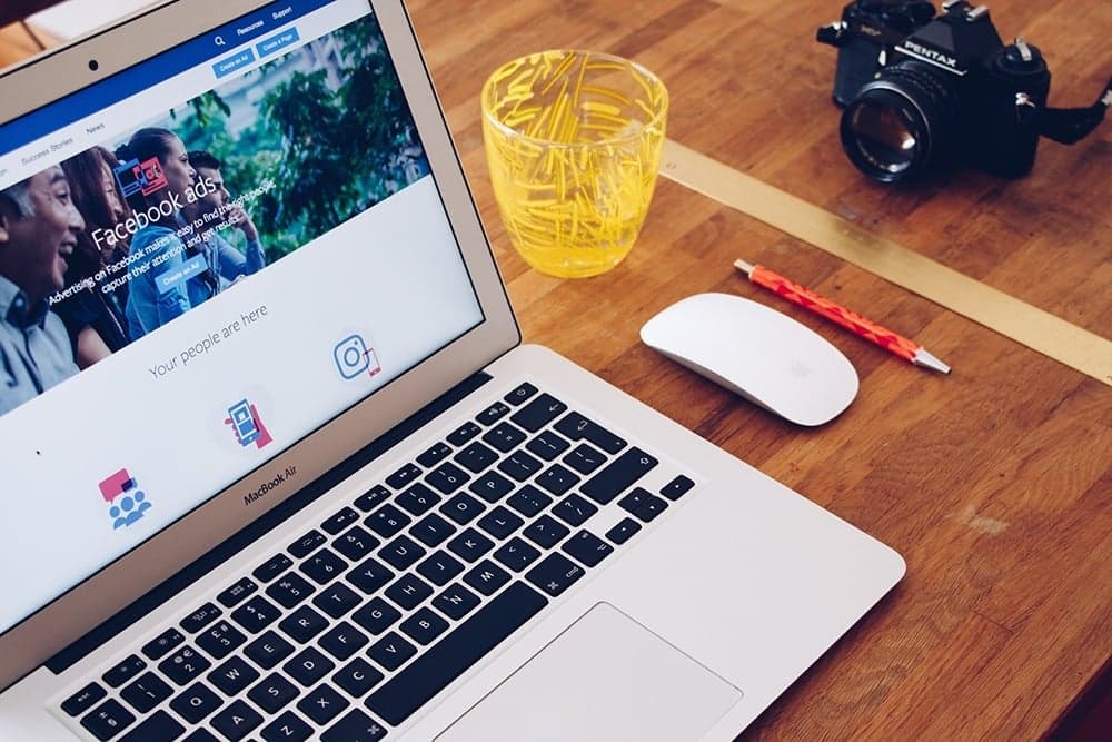 Facebook advertisement displayed on a laptop showing ads and video content