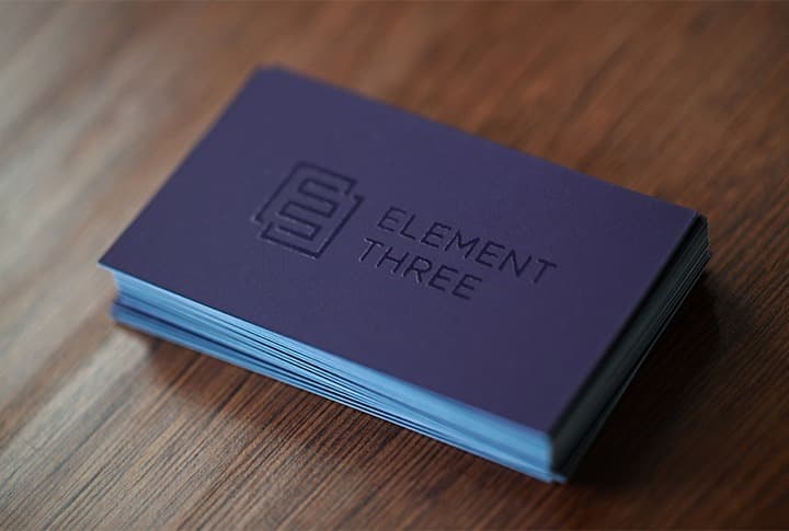 Stack of Element Three business cards with embossed logo