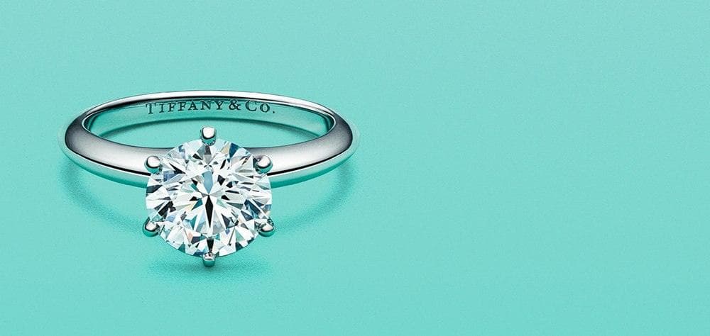 Tiffany & Co. diamond engagement ring on light blue background