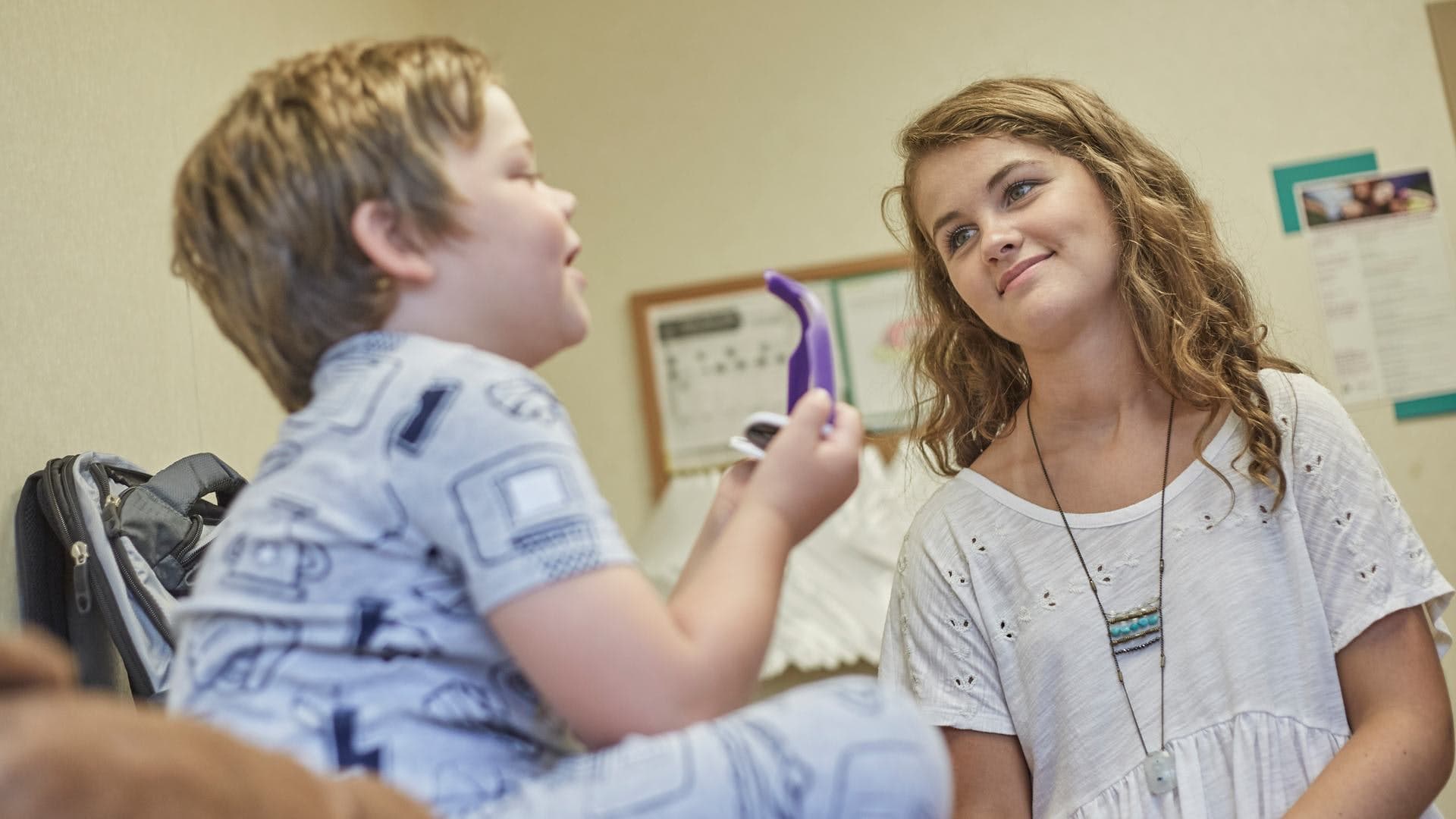 Boy and girl with purple instrument interacting in classroom setting