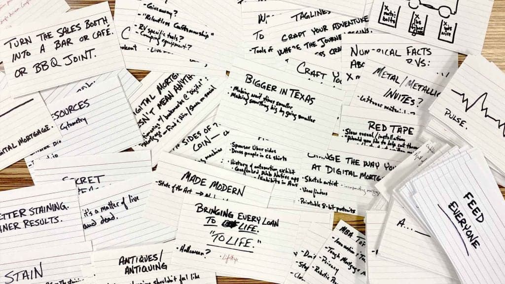 Handwritten notecards and planning notes on wooden surface