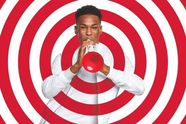 Man in white shirt against red concentric circles with thoughtful pose