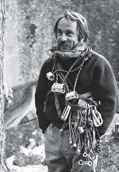 Black and white portrait of man with climbing gear and karabiners