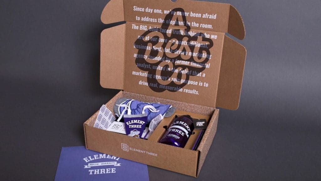 Brown cardboard box with Element Three branding containing branded items