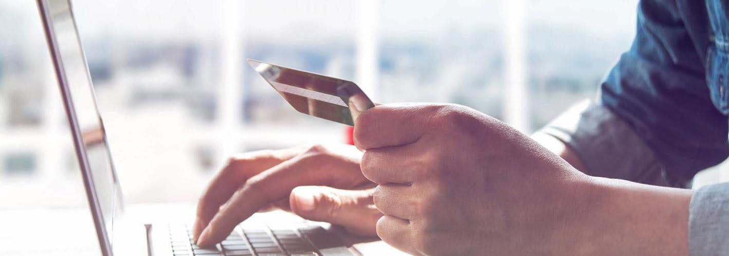 person using a credit card to buy something on his laptop