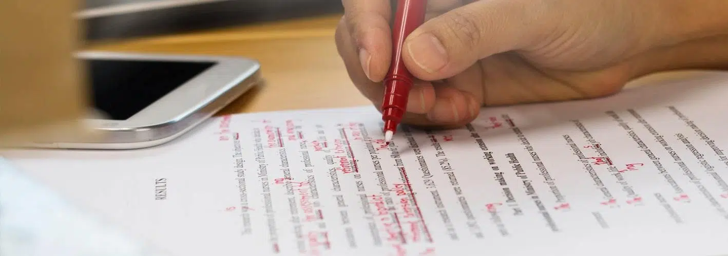 someone correcting a paper with a red pen