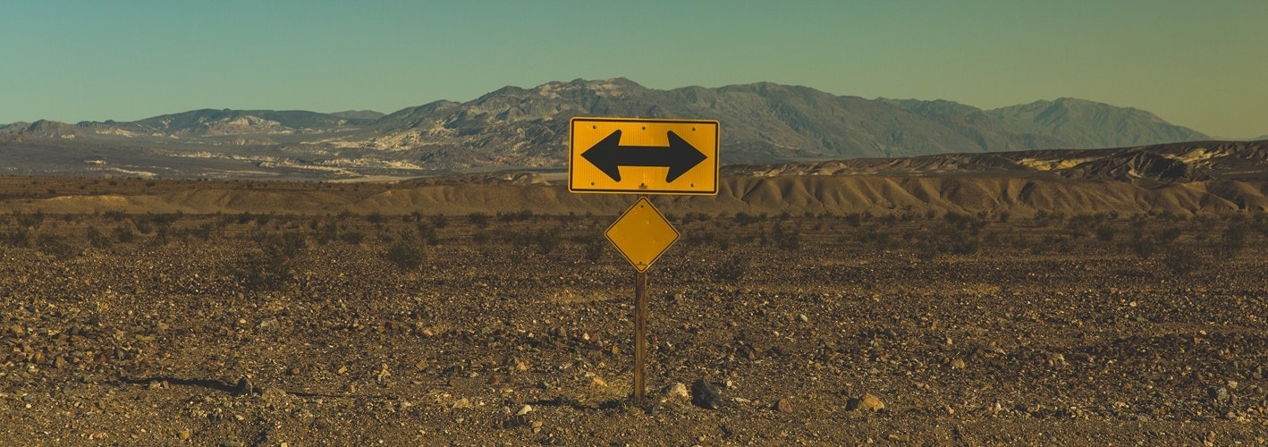 Road sign indicating a T in the road in the middle of a desert