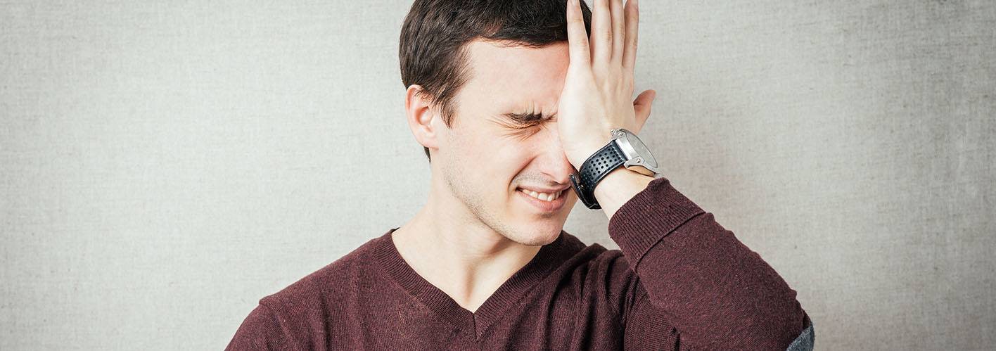 man slapping his own forehead in frustration