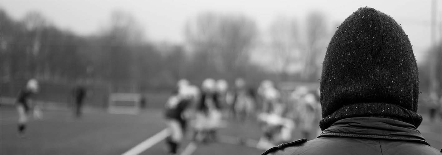 man in a hoodie at a football practice