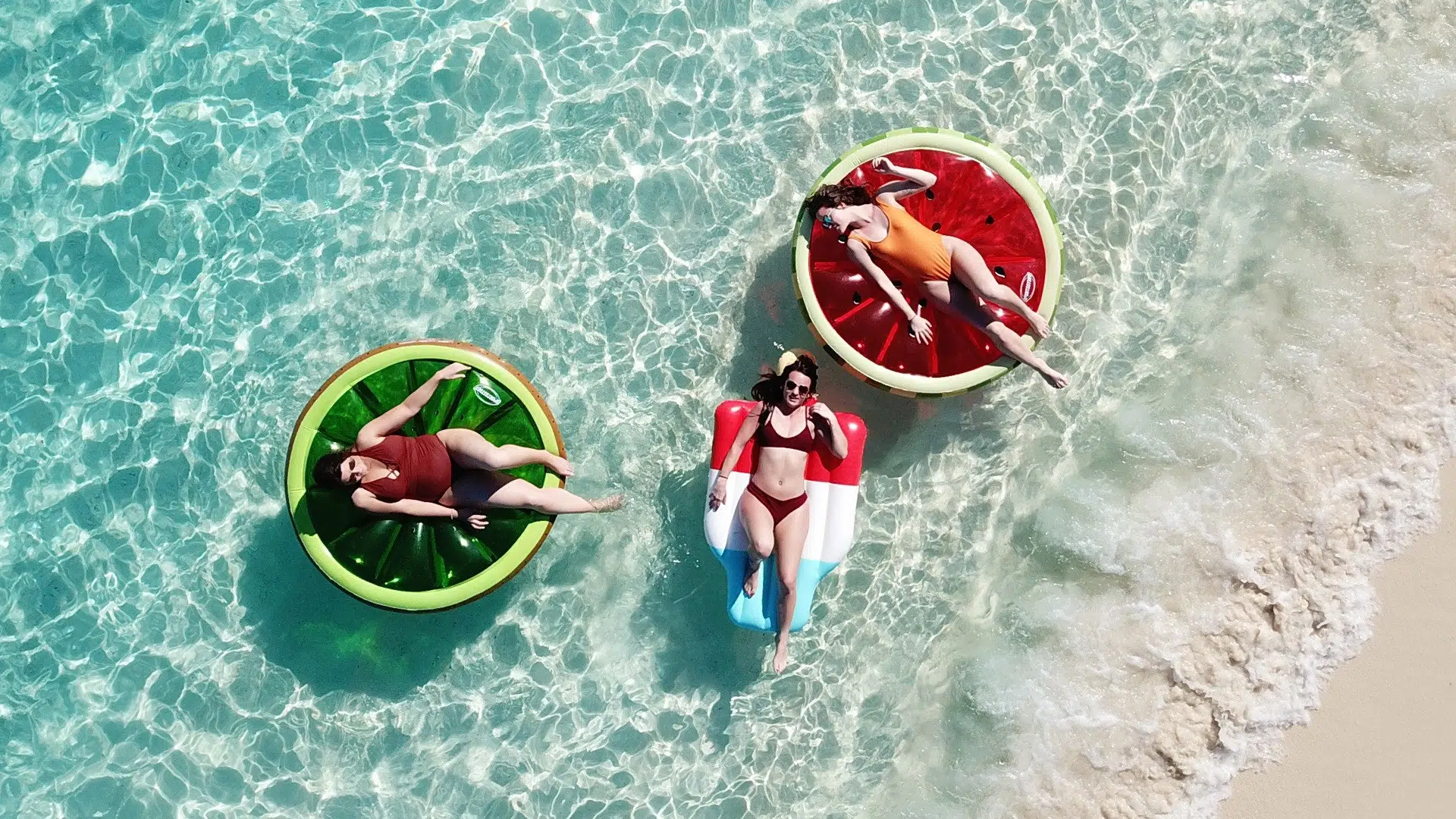 Three Millennials in Ocean on Pool Floats