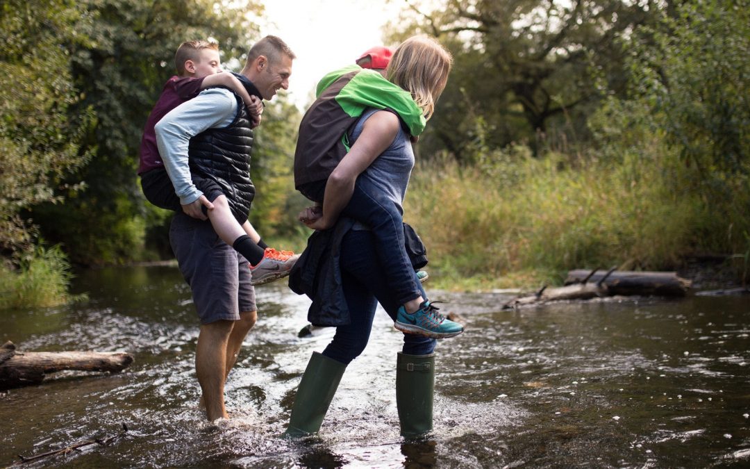 A Mother Child and Father Crossing a Creek
