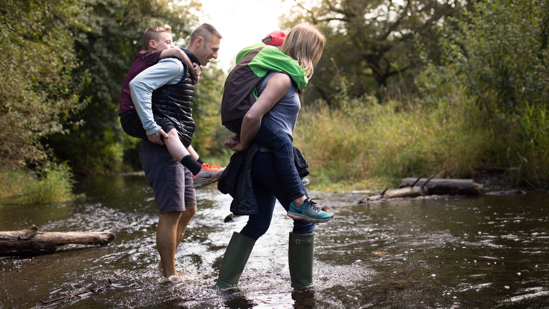 A Mother Child and Father Crossing a Creek