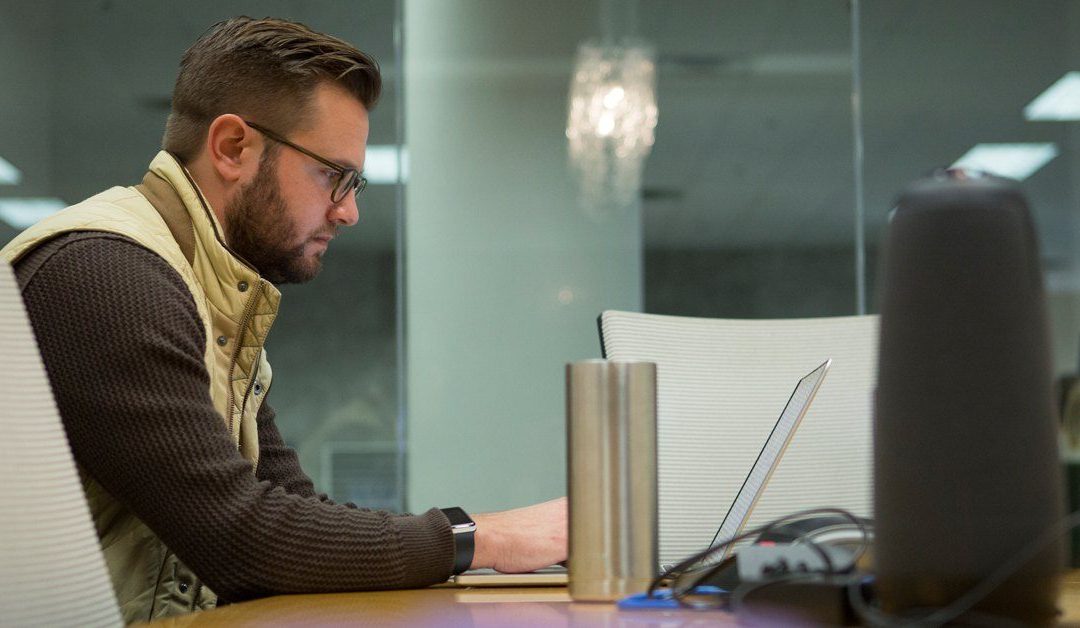 marketer typing at a computer in a conference room