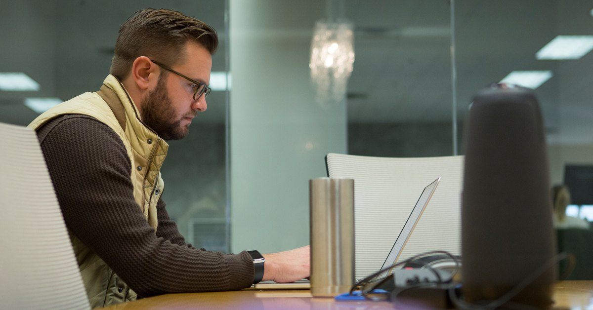 marketer typing at a computer in a conference room